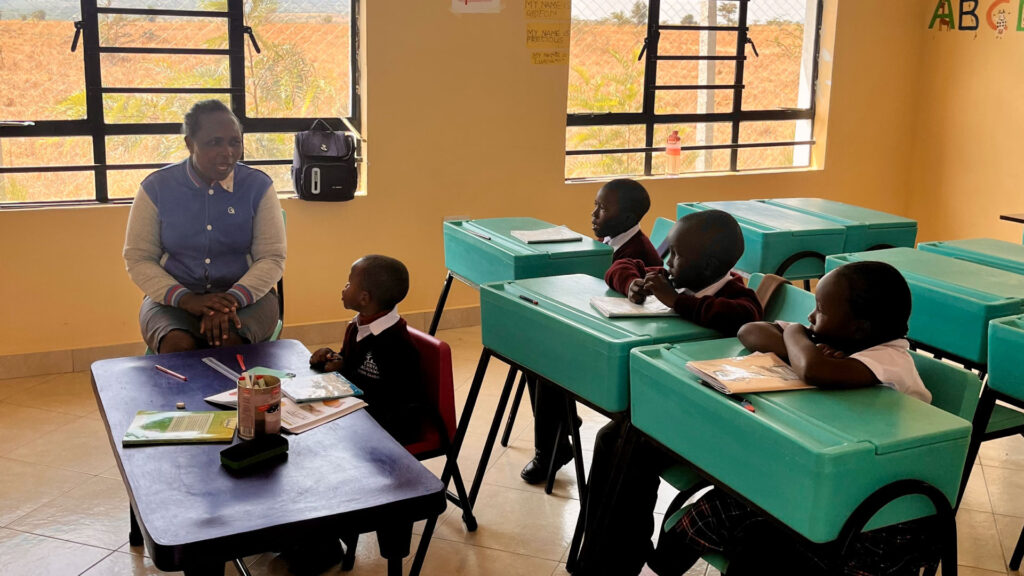 Ein Lied vor der ganzen Schule: Brandons Geschichte macht Mut 11 Eine Lehrerin sitzt mit vier Kindern im Klassenzimmer von Tumaini Ministries in Kenia.